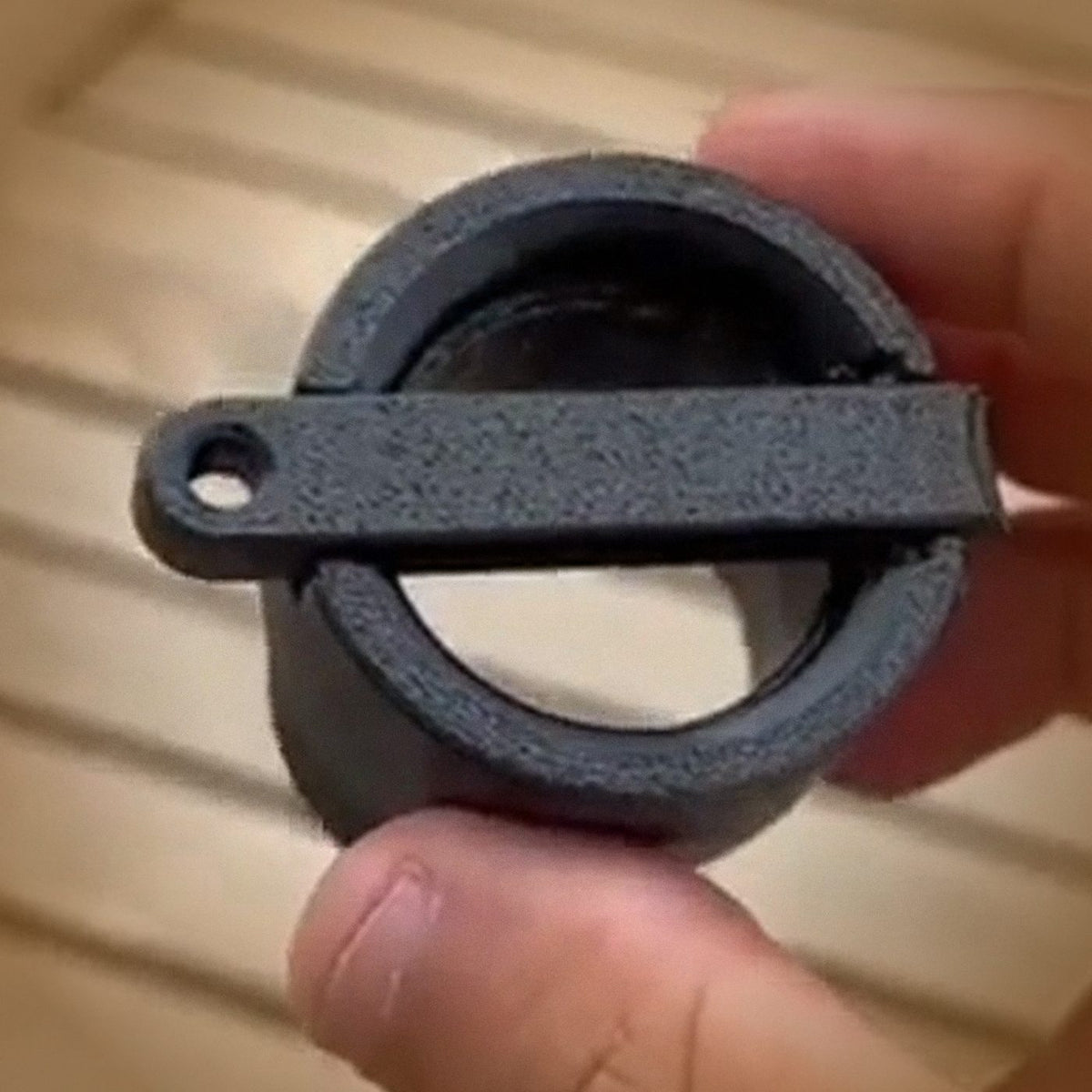 CapBlast bottle cap launcher held in hand, lever and open cup visible